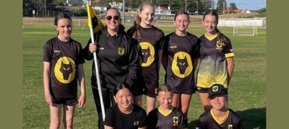 Coach and players of Warrnambool Wolves standing together at training 