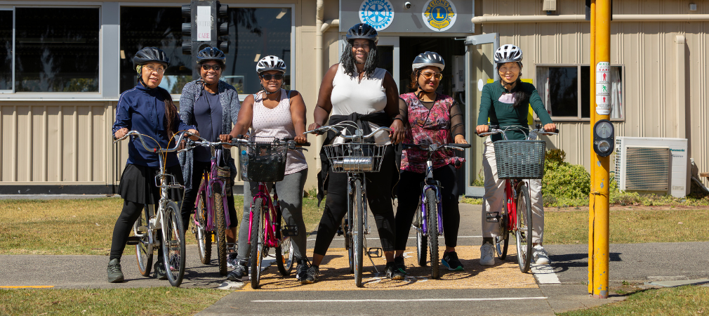 Multiple women learning to ride their bikes  