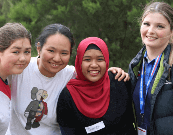 close up of four young women smiling at the camera.  