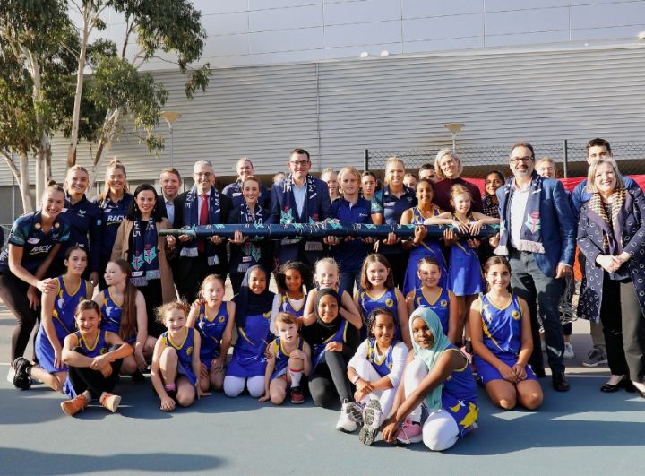 Group photo including government representatives, netball players and hockey players